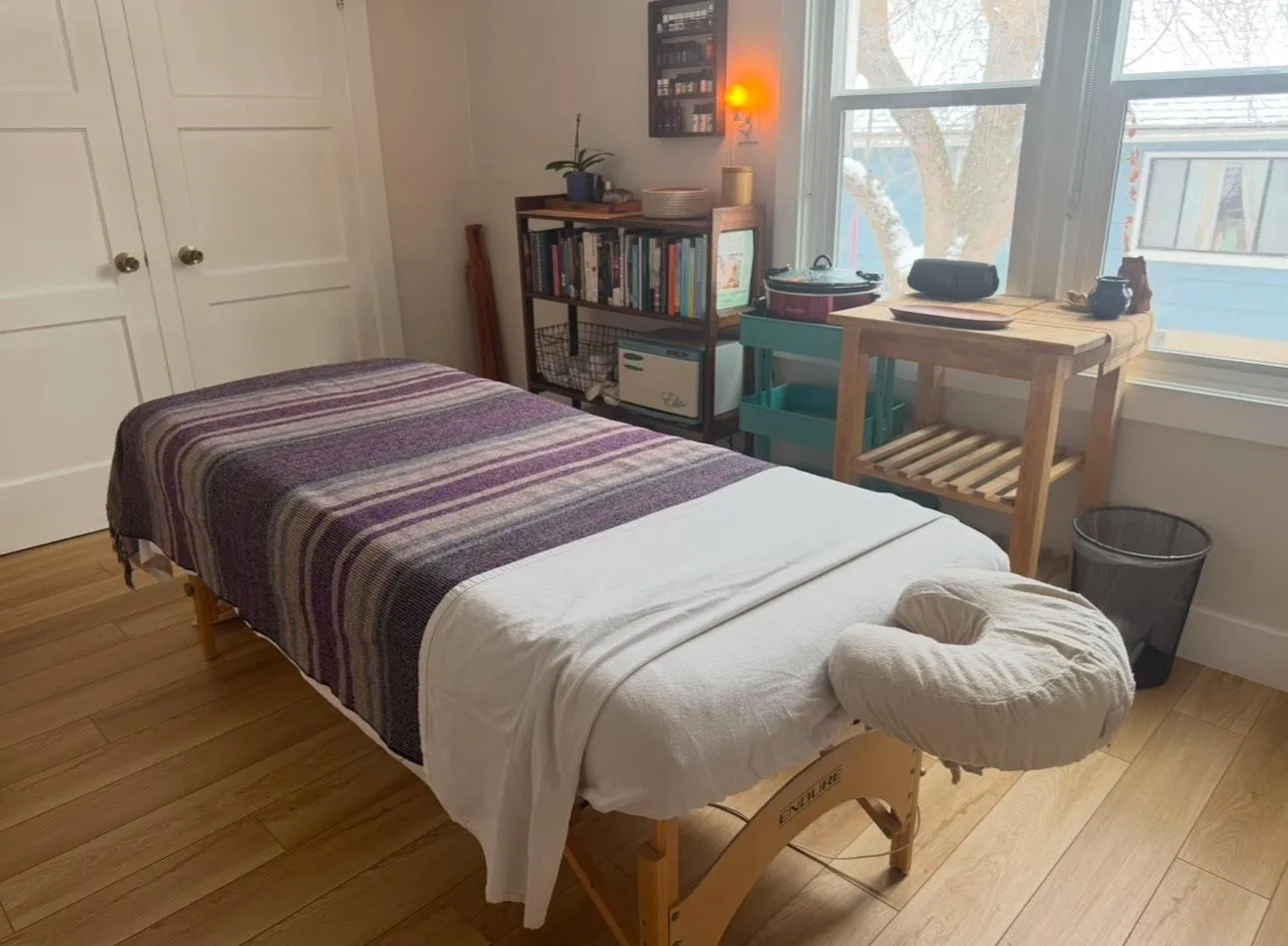 Briana's massage room, with a draped table beside a sunlit window